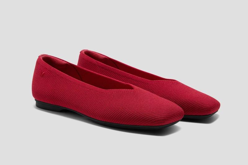 Pair of red knit ballet flats with black soles.